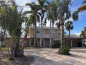 Two-story home with a paver driveway and lush landscaping at 4010 Belle Vista Dr, St Pete Beach, FL 33706