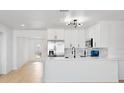 Modern white kitchen with stainless steel appliances and breakfast bar at 4120 82Nd N Ave, Pinellas Park, FL 33781