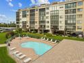 Kidney shaped community pool with patio furniture at 4650 Bay Blvd # 1046, Port Richey, FL 34668