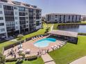 Community pool with patio furniture and adjacent building at 4650 Bay Blvd # 1046, Port Richey, FL 34668