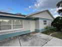 Front view of a ranch style home with a brick facade and well-maintained lawn at 8601 Twin Lakes Blvd, Tampa, FL 33614