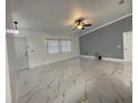 Bright living room featuring marble-look floors and a ceiling fan at 8601 Twin Lakes Blvd, Tampa, FL 33614