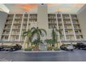 Exterior view of condo building with palm trees and parking at 1200 Country Club Dr # 2504, Largo, FL 33771
