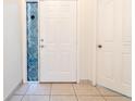 Welcoming front door with a stylish mosaic sidelight window and light tile flooring at 1515 Lions Club Dr, Brandon, FL 33511