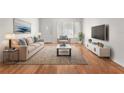 Living room with hardwood floors, sofa, and large TV at 2262 Swedish Dr # 12, Clearwater, FL 33763
