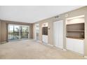 Living room with carpeting, sliding glass doors to balcony, and built-in shelving at 2320 Terra Ceia Bay Blvd # 403, Palmetto, FL 34221