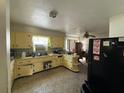 L-shaped kitchen with yellow cabinets and tiled floor at 1005 N Paddock Ave, Tampa, FL 33607