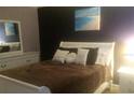 Sleigh bed, brown coverlet, white and gray pillows, dark walls and mirror at 18235 Bridle Club Dr # 18235, Tampa, FL 33647