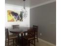 Dining table with four chairs, geometric light fixture, and modern wall art at 18235 Bridle Club Dr # 18235, Tampa, FL 33647