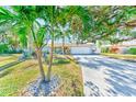 Single-story home with palm trees and landscaped yard at 320 Mimosa Cir, Sarasota, FL 34232