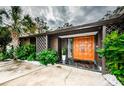 Inviting entryway with orange double doors and lush landscaping at 3311 San Mateo St, Clearwater, FL 33759