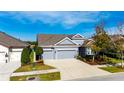 Two-story home with gray exterior, three-car garage, and landscaped yard at 7506 Parkshore Dr, Apollo Beach, FL 33572