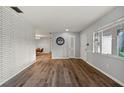 Living room with gray walls, wood floors, and white brick accent wall at 7810 N 53Rd St, Tampa, FL 33617