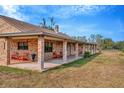 Brick ranch home with a large covered porch and rocking chairs at 9229 Fort King Rd Rd, Dade City, FL 33525