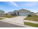 Front view of a single story house with a two-car garage at 10303 Charlotte Dr, Parrish, FL 34219
