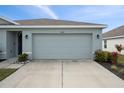 Two-car garage with light gray doors and exterior lighting at 10303 Charlotte Dr, Parrish, FL 34219