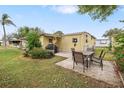 Backyard patio with table and chairs, adjacent to yellow single-wide mobile home at 27466 Us Highway 19 N # 103, Clearwater, FL 33761