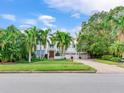 White two-story house with palm trees and a brick driveway at 334 Blanca Ave, Tampa, FL 33606