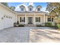 Elegant home's entrance with a three-car garage and a brick paved driveway at 6099 Summit View Dr, Brooksville, FL 34601