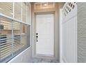 White front door with sidelight window and stone flooring at 11008 Windsor Place Cir, Tampa, FL 33626