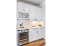 White kitchen cabinetry with wine rack and beverage cooler at 11334 Shoreline Trl, Parrish, FL 34219