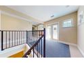Hallway leading to an outdoor patio featuring iron railings and blue carpet at 1149 Sedeeva St, Clearwater, FL 33755