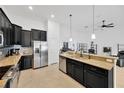 Open kitchen with dark cabinets, granite countertops, and stainless steel appliances at 11926 Cinnamon Fern Dr, Riverview, FL 33579