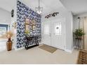 Entryway with dark console table, patterned wallpaper, and double doors at 14816 Dartmoor Ln, Tampa, FL 33624