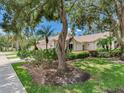 Well manicured front yard featuring mature landscaping and verdant green grass at 6325 Stone River Rd, Bradenton, FL 34203