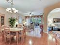Bright living room featuring hardwood floors, chandelier, and sliding door to patio at 6325 Stone River Rd, Bradenton, FL 34203