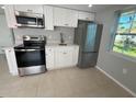 Modern kitchen with stainless steel appliances and white cabinets at 735 Bertrend St, Englewood, FL 34223