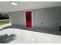 Covered side porch with red door access at 735 Bertrend St, Englewood, FL 34223
