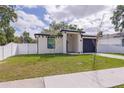Charming home featuring a gray garage door, red front door and well-maintained green lawn at 8317 N Ogontz Ave, Tampa, FL 33604