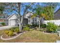 House exterior with lush landscaping and a gray color scheme at 6106 36Th Ct E, Ellenton, FL 34222