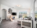Bright living room with modern decor, gray plank floors, large windows, and sliding glass doors to the backyard at 7833 Carriage Pointe Dr, Gibsonton, FL 33534