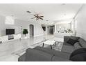 Spacious living room featuring tile floors, a ceiling fan, and abundant natural light at 4205 Morning Breeze Ct, Tampa, FL 33619