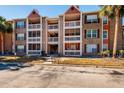 View of a two-story apartment building with balconies, palm trees, and a walkway at 10200 Gandy N Blvd # 1313, St Petersburg, FL 33702