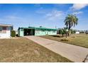 Mint green house with palm tree and a long driveway at 1535 Council Dr, Sun City Center, FL 33573
