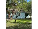 Rear view of a light blue house, surrounded by lush greenery at 1714 2Nd E Ave, Bradenton, FL 34208