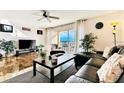Living room with water view, leather couch, and large TV at 19811 Gulf Blvd # 102, Indian Shores, FL 33785