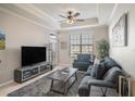 Inviting living room with tray ceiling, neutral paint, ceiling fan and comfortable seating at 4221 W Spruce St # 2418, Tampa, FL 33607