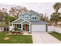 Two-story craftsman home with orange door and landscaped yard at 511 Roanoke St, Dunedin, FL 34698