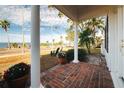 Brick porch with white columns, offering water views and a relaxing atmosphere at 55 Edgewater Dr, Dunedin, FL 34698
