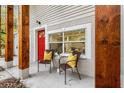 Relaxing front porch with seating, a red door, and wooden accents at 807 E Genesee St # 1/2, Tampa, FL 33603