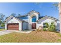 Two-story house with a brick facade, brown garage door, and a landscaped yard at 10210 Rainbridge Dr, Riverview, FL 33569