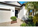 Inviting front entrance with a black door and landscaping at 13210 Orca Sound Dr, Riverview, FL 33579