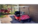 Red golf cart parked in driveway of a home at 12115 Amica Loop, Venice, FL 34293