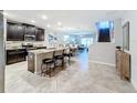 Modern kitchen with dark cabinetry, granite island, and stainless steel appliances at 16847 Whisper Elm St, Wimauma, FL 33598