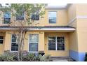 Two-story yellow house with a covered entryway and landscaping at 37670 Aaralyn Rd, Zephyrhills, FL 33542