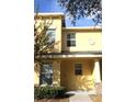 Front view of a two-story townhome, showcasing its light-yellow facade at 37715 Aaralyn Rd, Zephyrhills, FL 33542